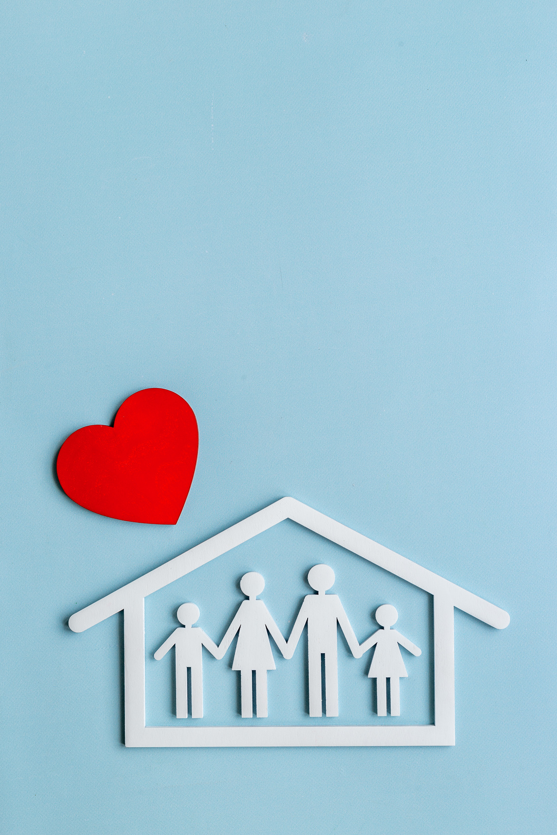 Family figure in wooden house with heart shape. Happy family, protection concept